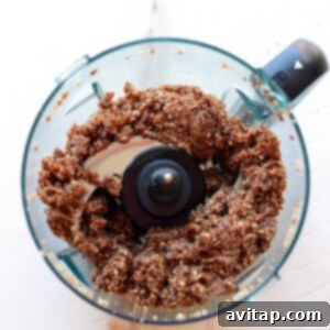 All ingredients for cherry pie energy balls blending into a cohesive dough in a food processor.