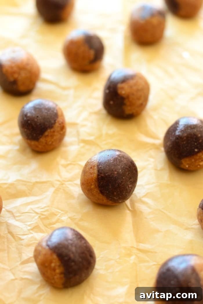 Two-toned peanut butter and jelly energy balls on a plate, showcasing the distinct layers of nut and fruit.