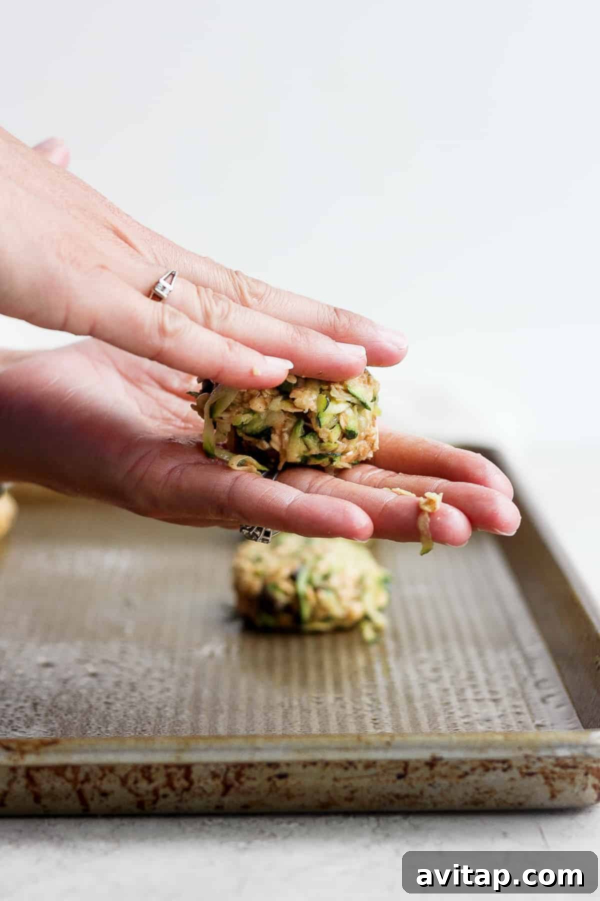 Healthy Oatmeal Zucchini Cookies 8 Hands pressing down cookie dough on a baking sheet.