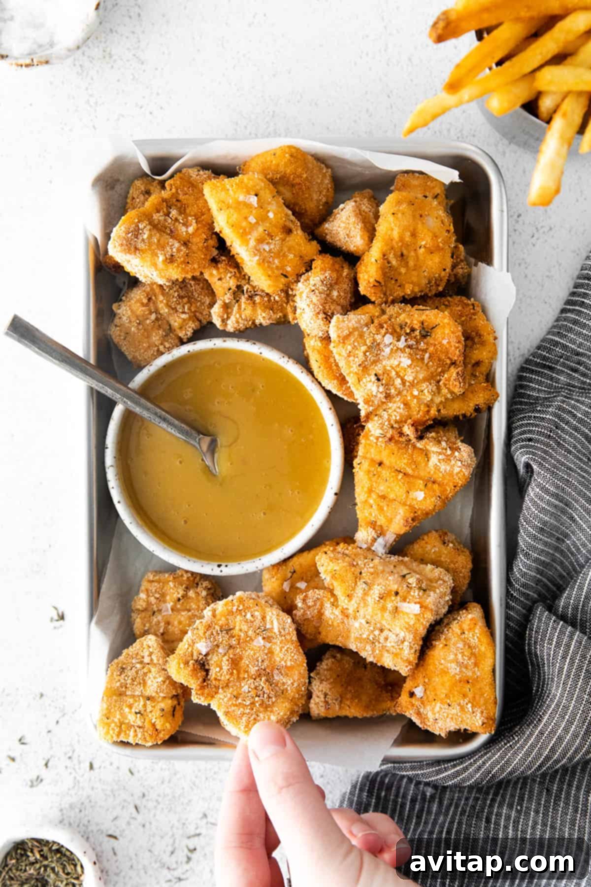 Golden brown crispy homemade chicken nuggets on a baking sheet, ready to be served.
