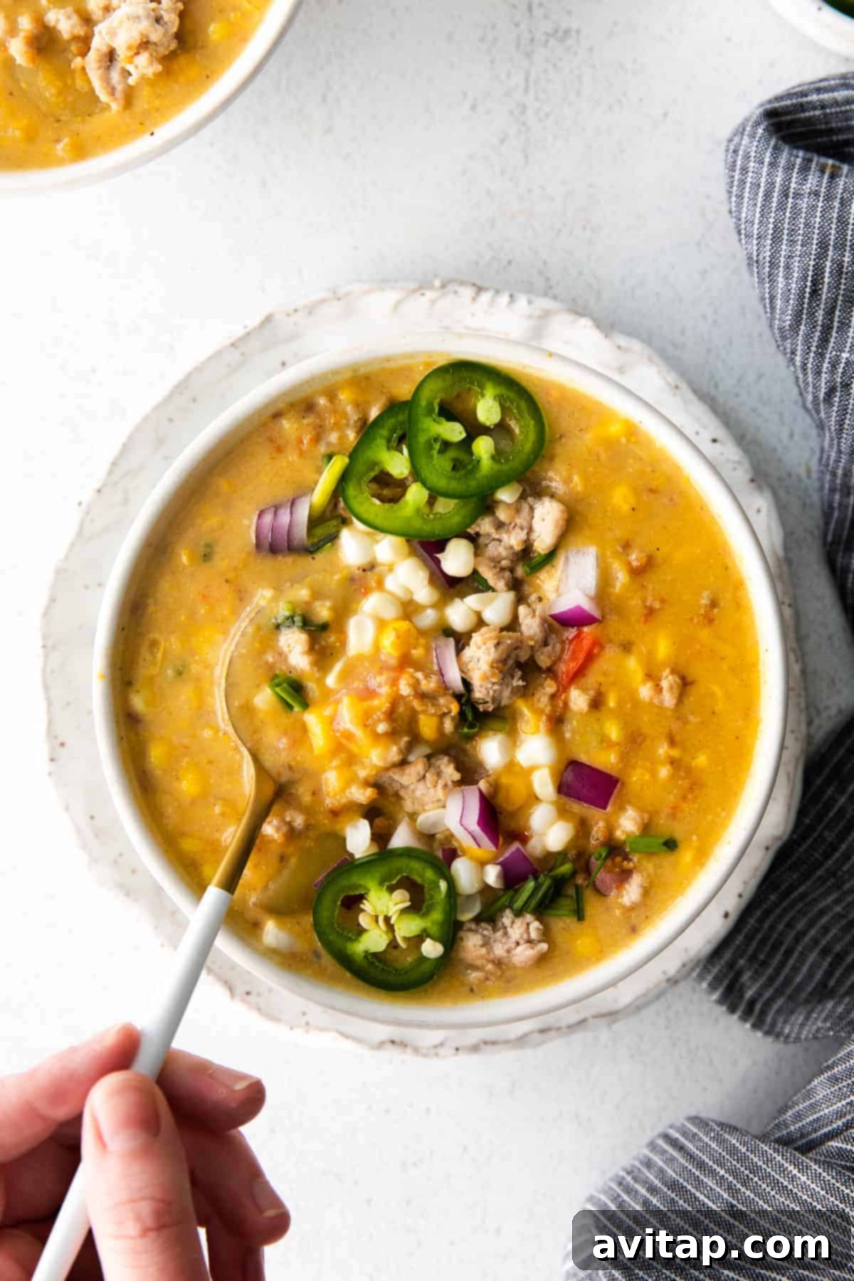 Delicious creamy corn chowder served in a bowl, garnished with fresh herbs.