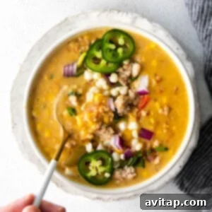 Creamy Corn Chowder in a rustic bowl, garnished with fresh herbs and crispy pork.