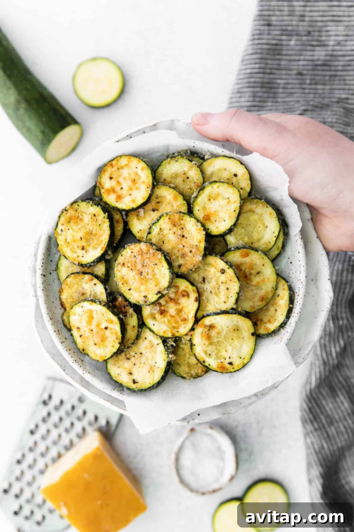 Crispy air fryer zucchini in a rustic bowl, garnished with fresh parsley.