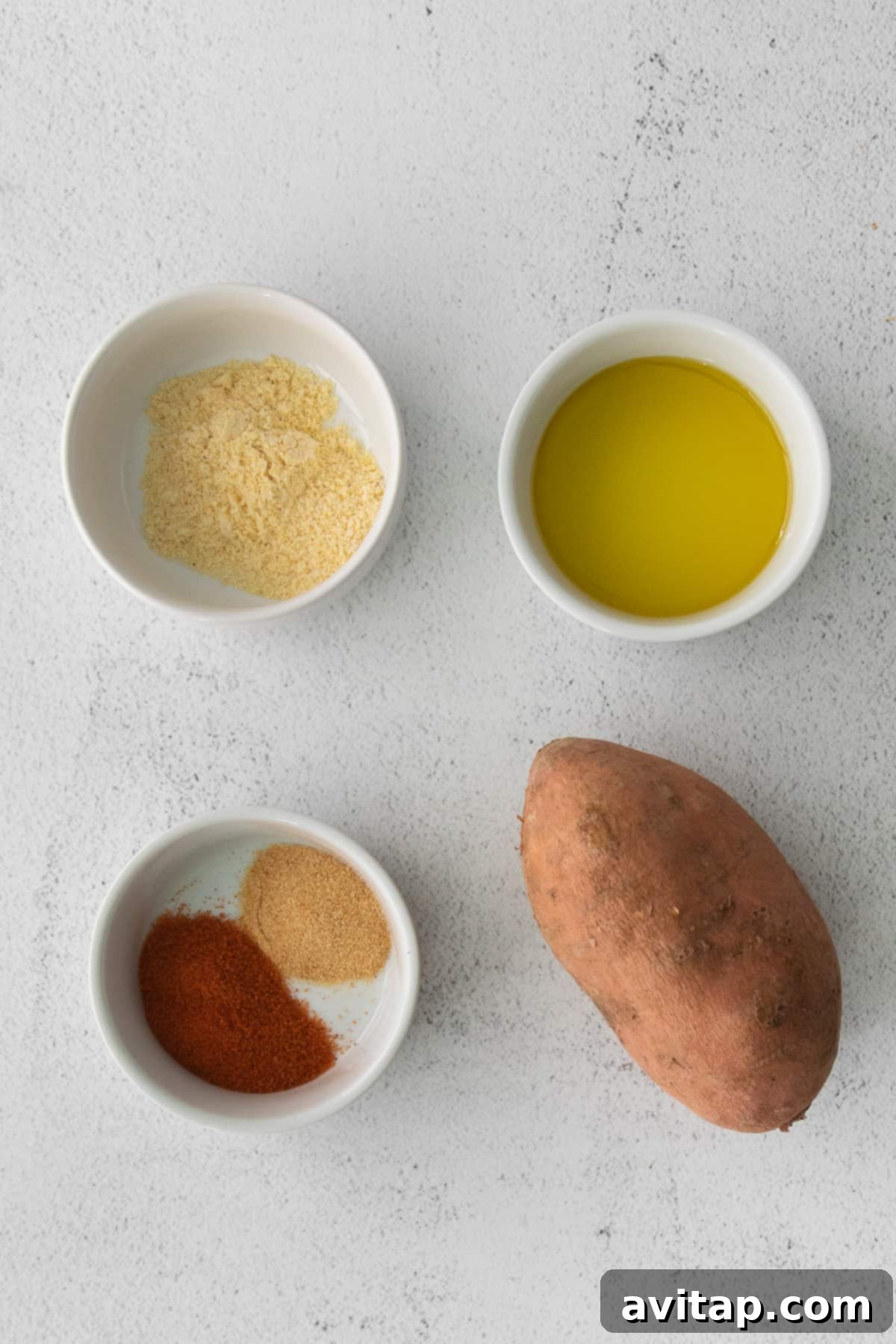 Air-Fried Sweet Potato Perfection 3 Bowls of ingredients for air fryer sweet potato fries: sliced sweet potatoes, olive oil, seasoned salt, garlic powder, and cornmeal