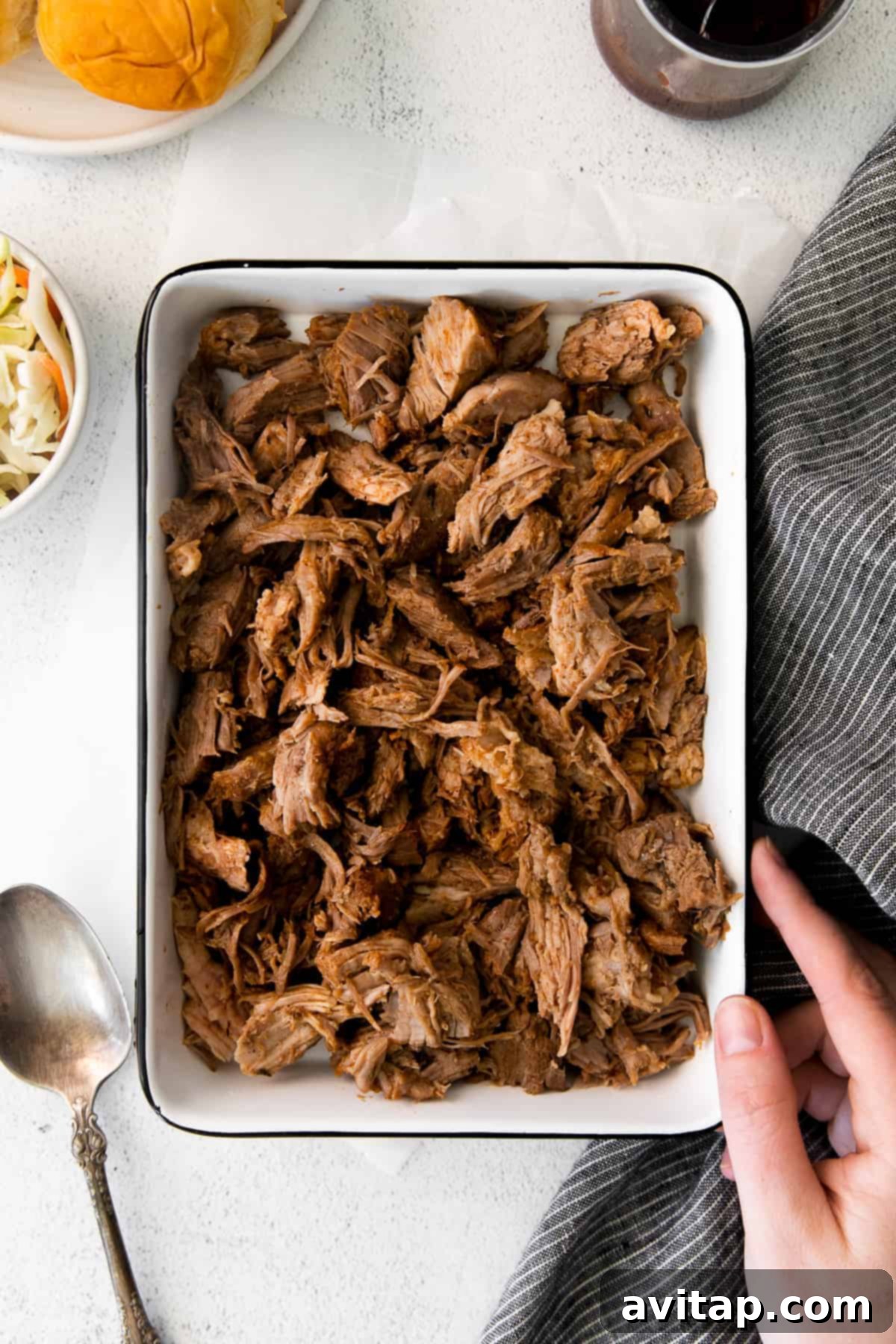 The best slow cooker pulled pork recipe for easy entertaining Tender pulled pork served in a dish, ready to eat