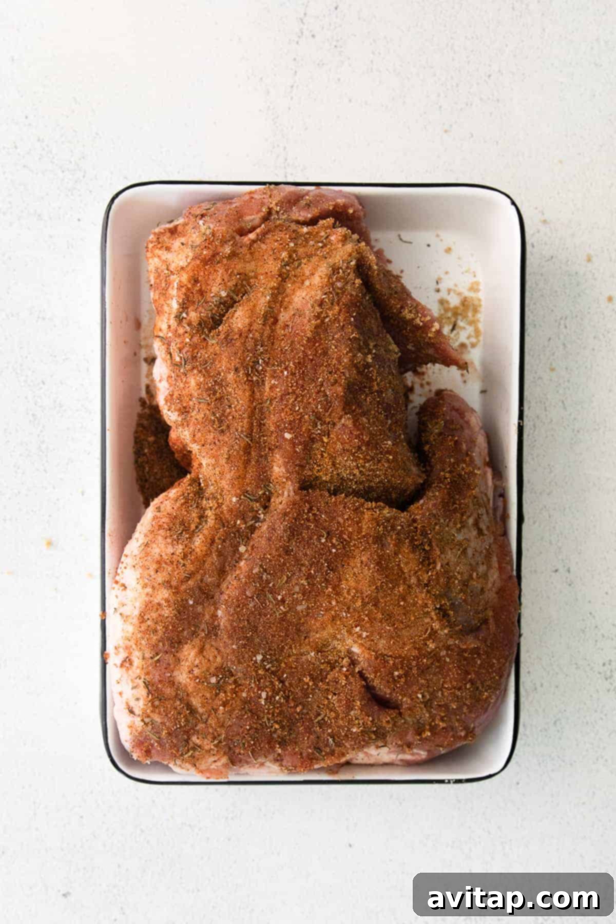 Flavorful dry rub applied to pork shoulder for slow cooking Pork shoulder generously seasoned with a dry rub