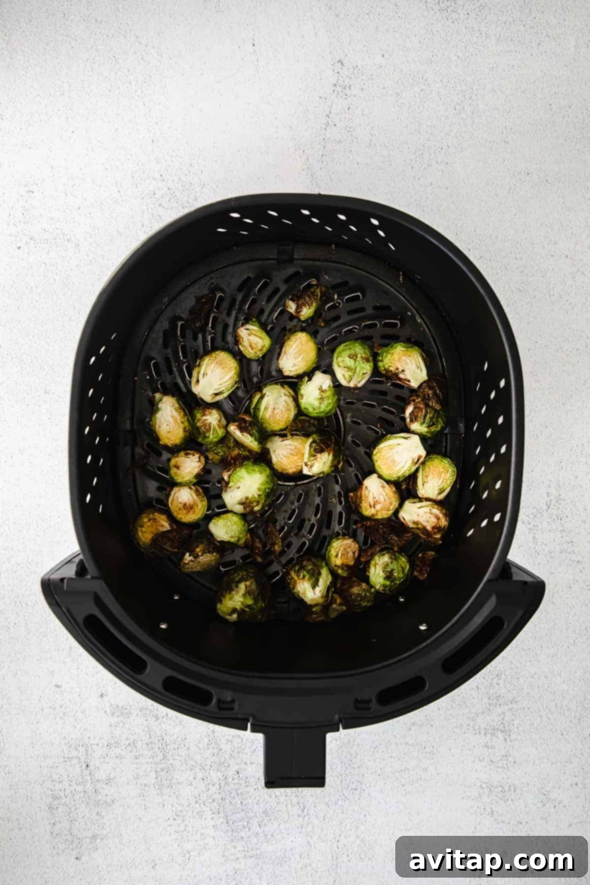 Close-up of golden-brown air fryer Brussels sprouts with crispy edges, ready to be served.