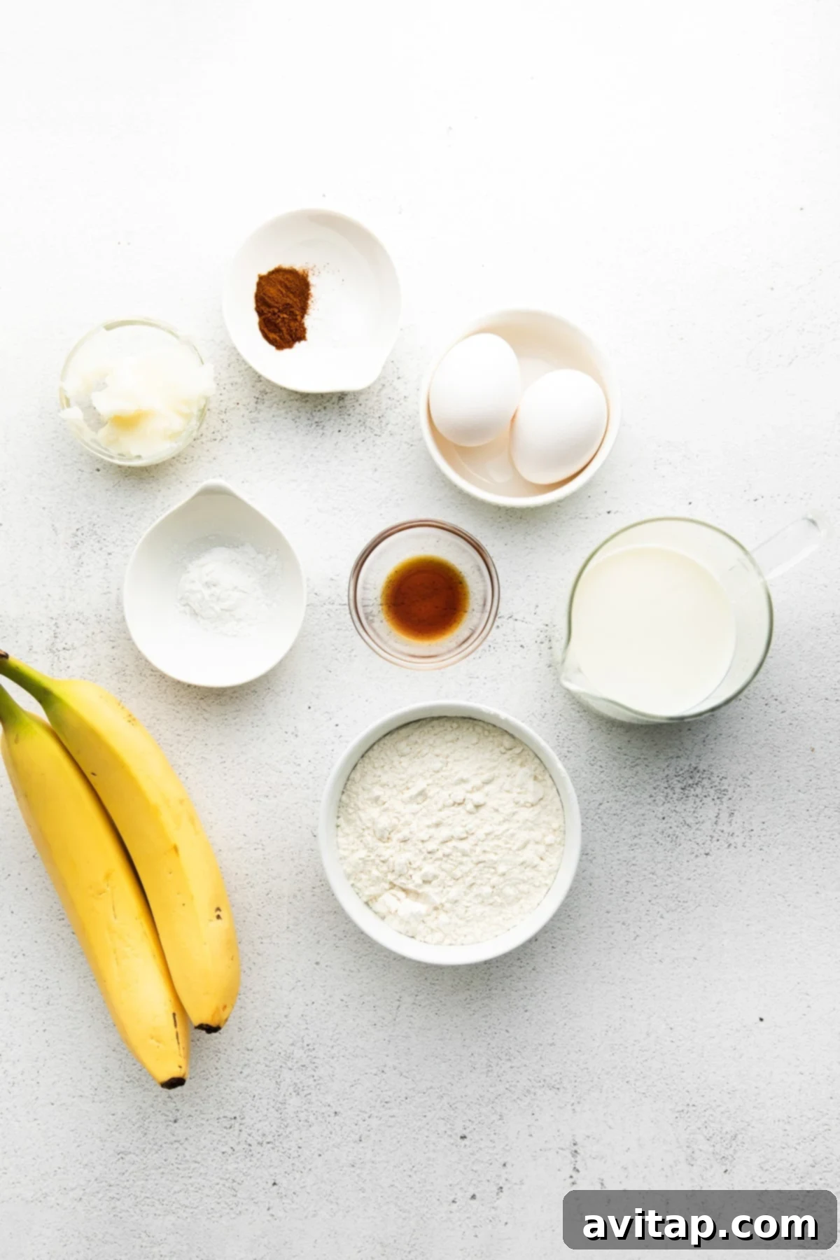 Essential Ingredients for Healthy Banana Pancakes A collection of fresh ingredients for banana pancakes laid out on a kitchen counter, including ripe bananas, whole wheat flour, eggs, and coconut oil.