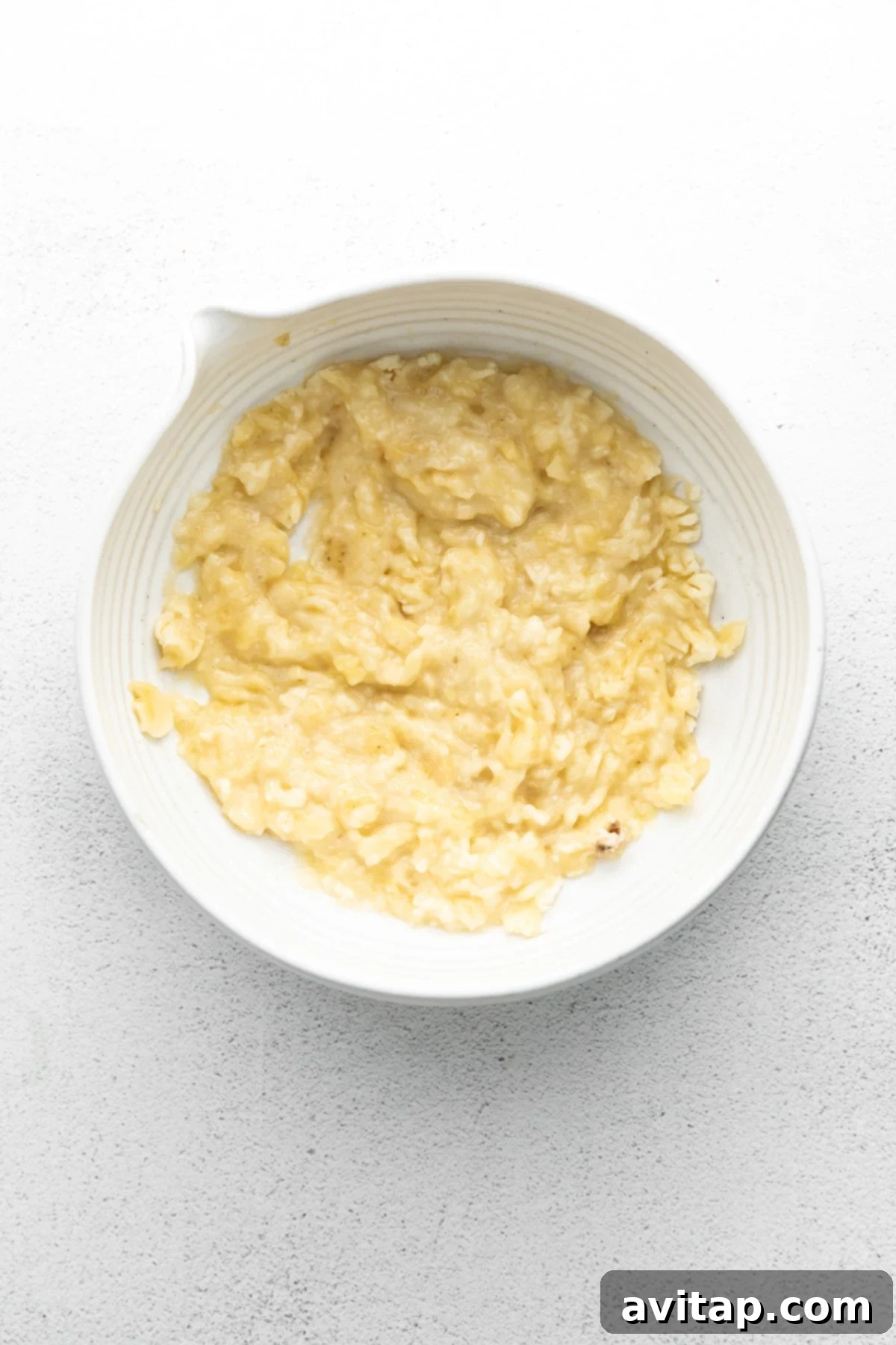 Mashed Ripe Bananas for Pancake Batter A bowl of perfectly mashed ripe bananas, showing a creamy texture, ready to be incorporated into the pancake batter