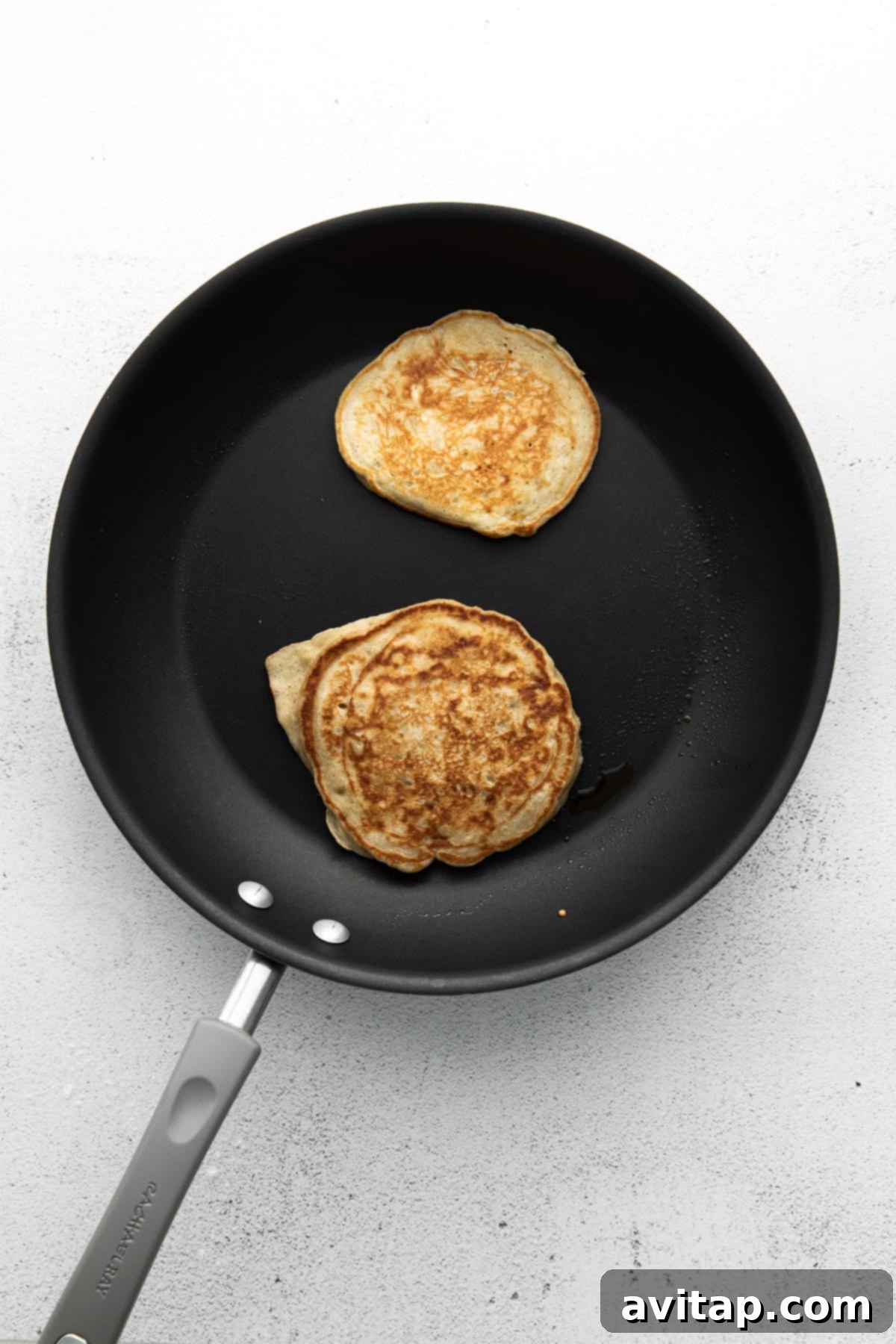 Cooking Banana Pancakes on a Griddle Banana pancakes cooking on a hot griddle, showing their golden brown exterior