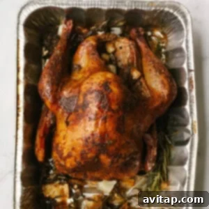 Smoked Turkey Perfection 18 A golden-brown smoked turkey in an aluminum foil pan, freshly removed from the smoker.