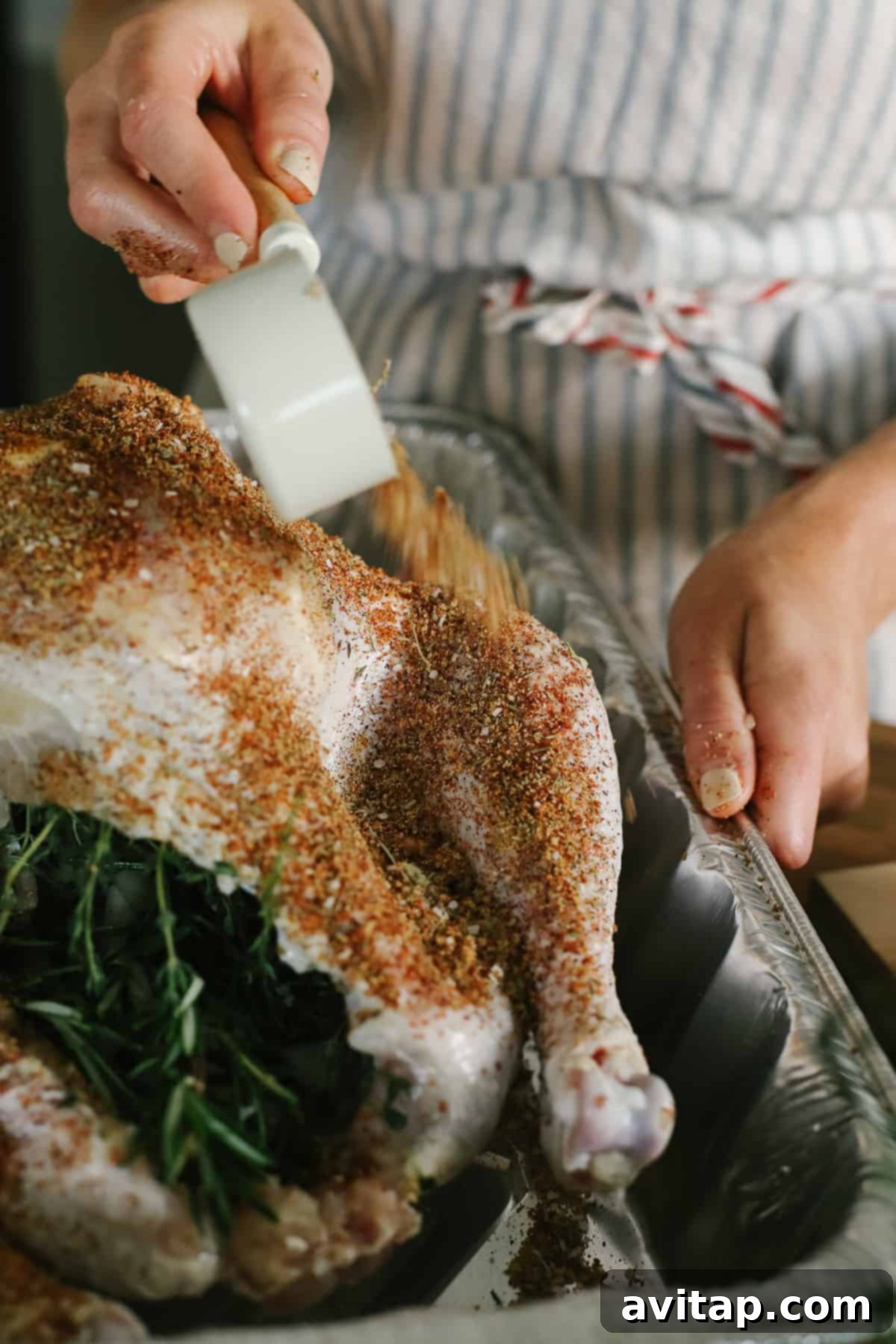 Smoked Turkey Perfection 3 Hands carefully seasoning a whole turkey with a dry rub, ensuring every crevice is covered before smoking.