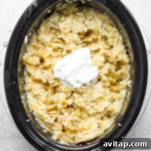 Mashed potatoes in crock pot with Greek yogurt being added