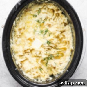 A crock pot filled with mashed potatoes and dill.