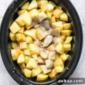A crock pot filled with chopped apples.