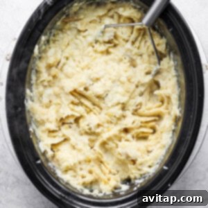 Cooked tender potatoes in a slow cooker, ready for mashing