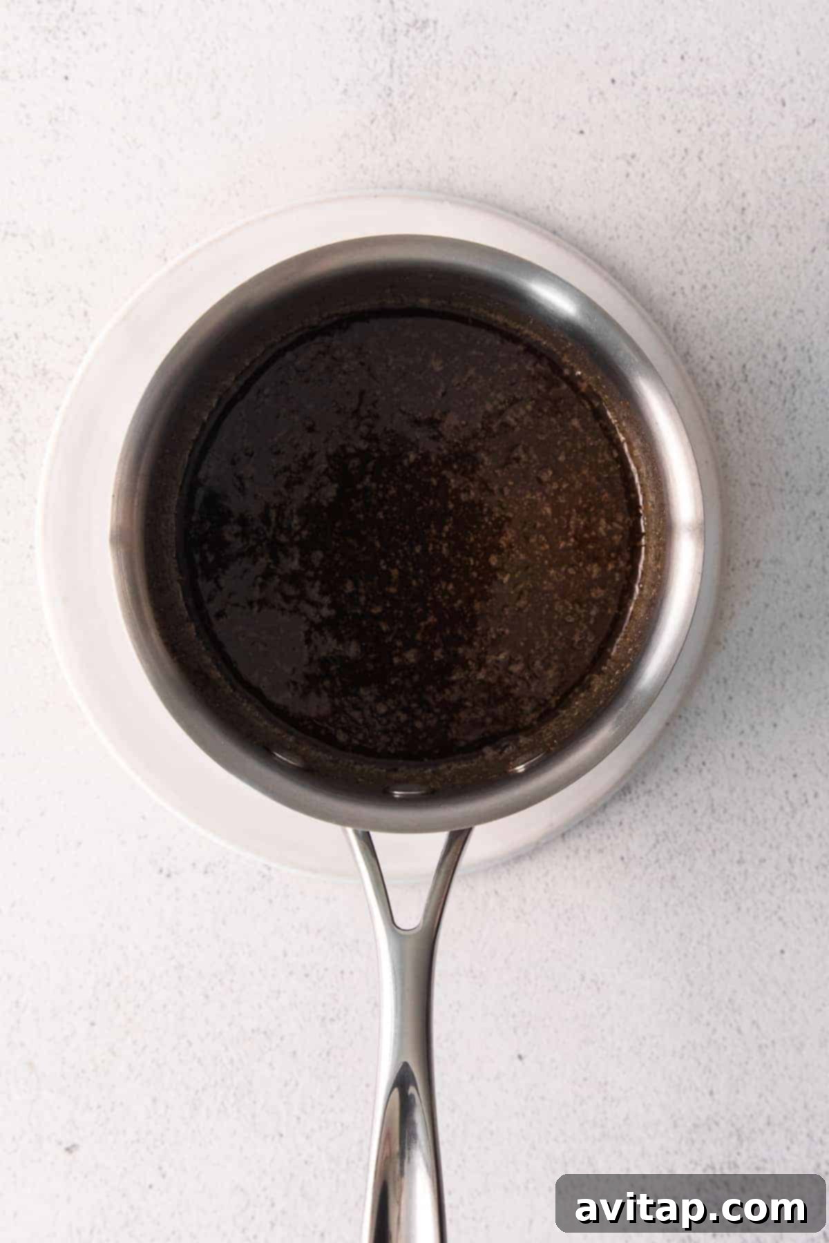 Close-up of the delicious chai syrup simmering in a small saucepan, ready to coat the Chex Mix ingredients.