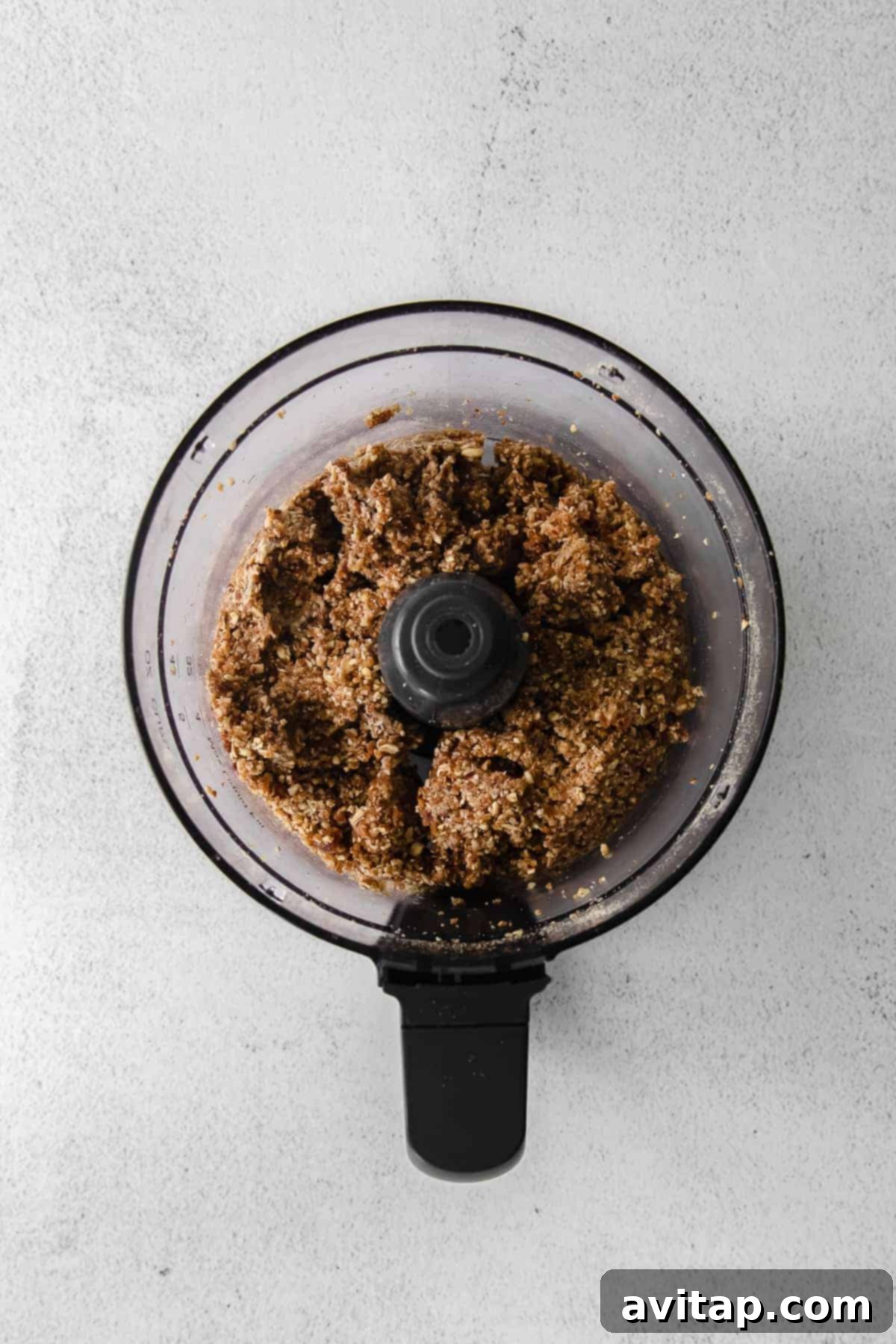 Pecan pie energy balls dough actively mixing in a food processor, showing the process of combining ingredients.