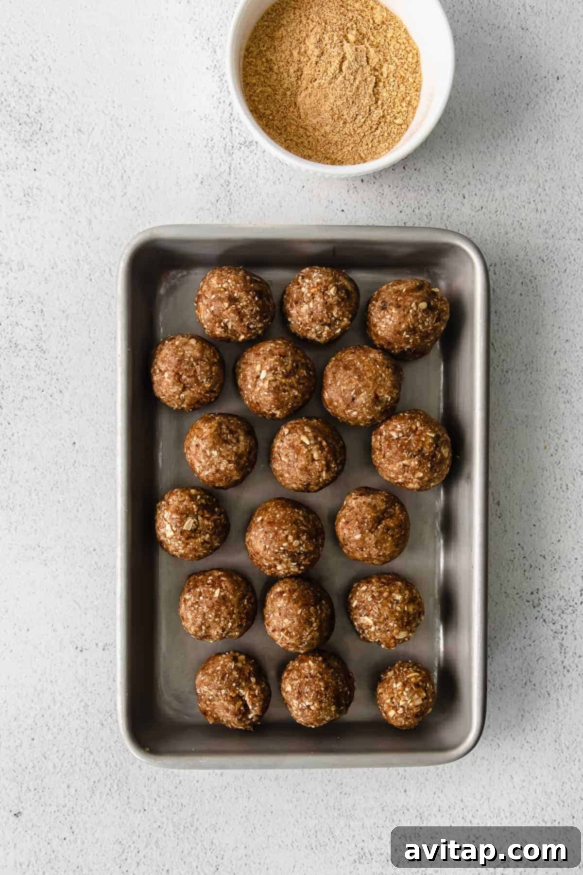 Freshly rolled pecan pie energy balls arranged neatly on a baking sheet, ready for chilling.