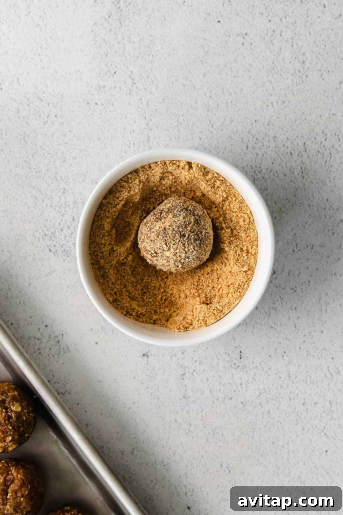 A single pecan pie energy ball, perfectly rolled in graham cracker crumbs, showcasing its delicious texture.