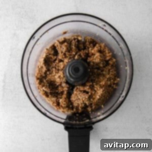 A food processor filled with a brown mixture, the base for pecan pie energy balls.
