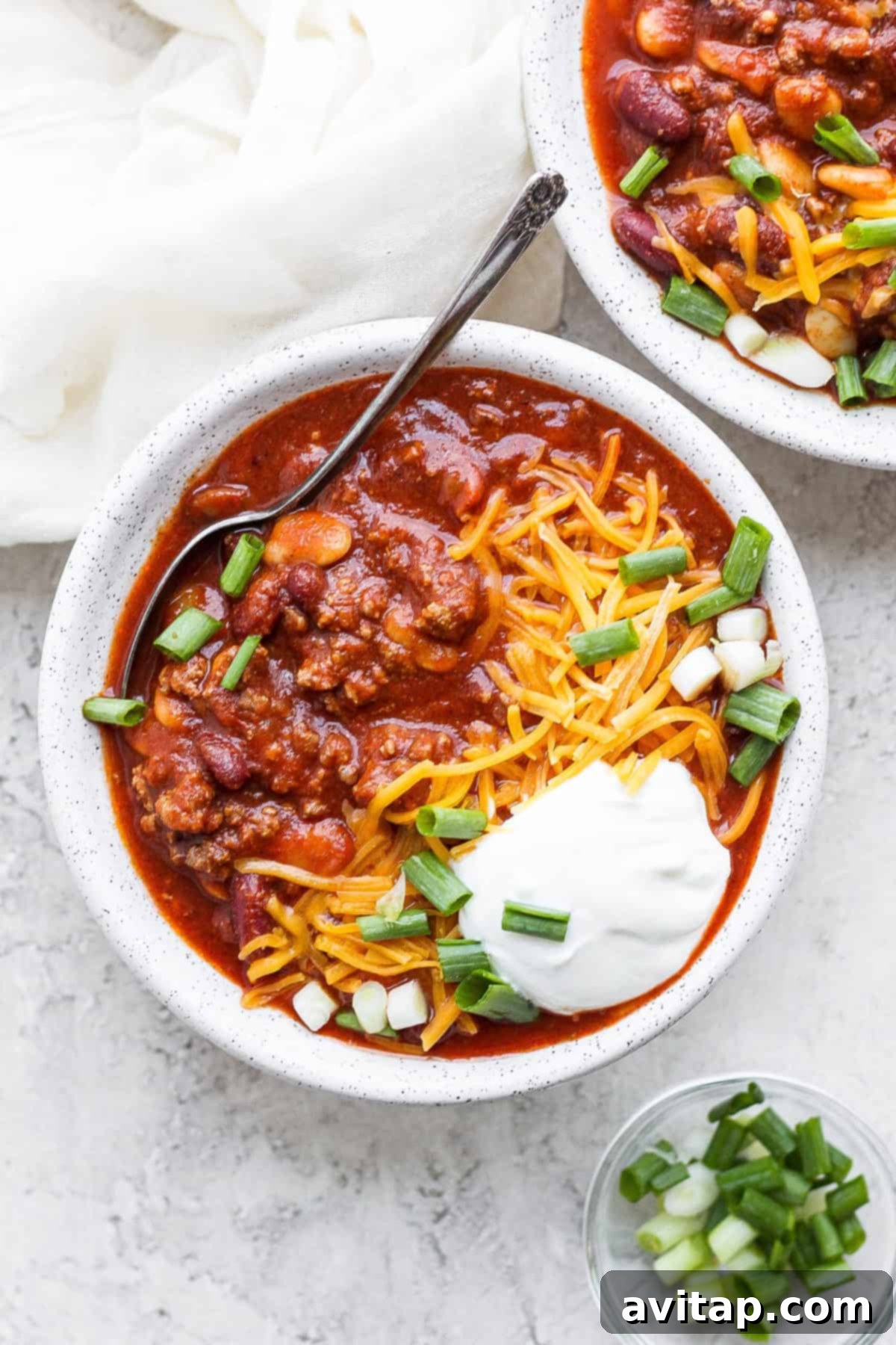 A steaming bowl of slow cooker chili, garnished with fresh cilantro, ready to be enjoyed.