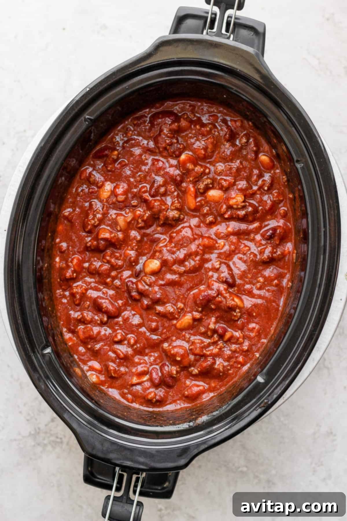 A vibrant, delicious slow cooker chili bubbling in the crockpot, ready to be served.