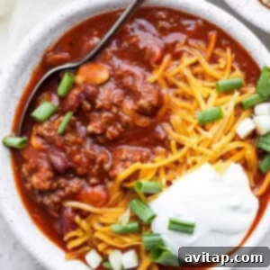 Slow cooker chili with sour cream and green onions.