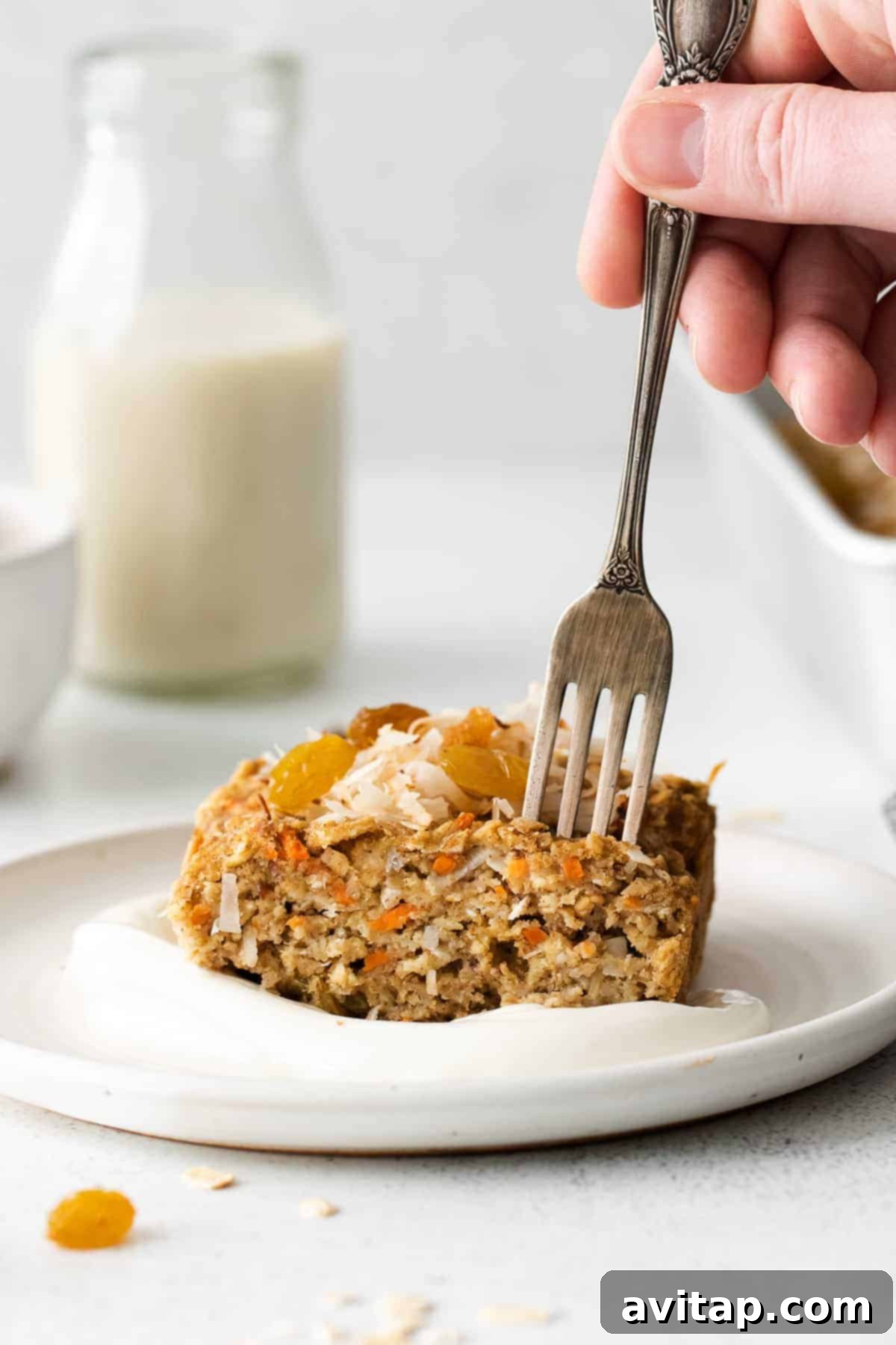 Morning Glory Baked Oatmeal Slice with Flaked Coconut A delectable slice of Morning Glory Baked Oatmeal, beautifully topped with toasted flaked coconut, ready to be enjoyed.