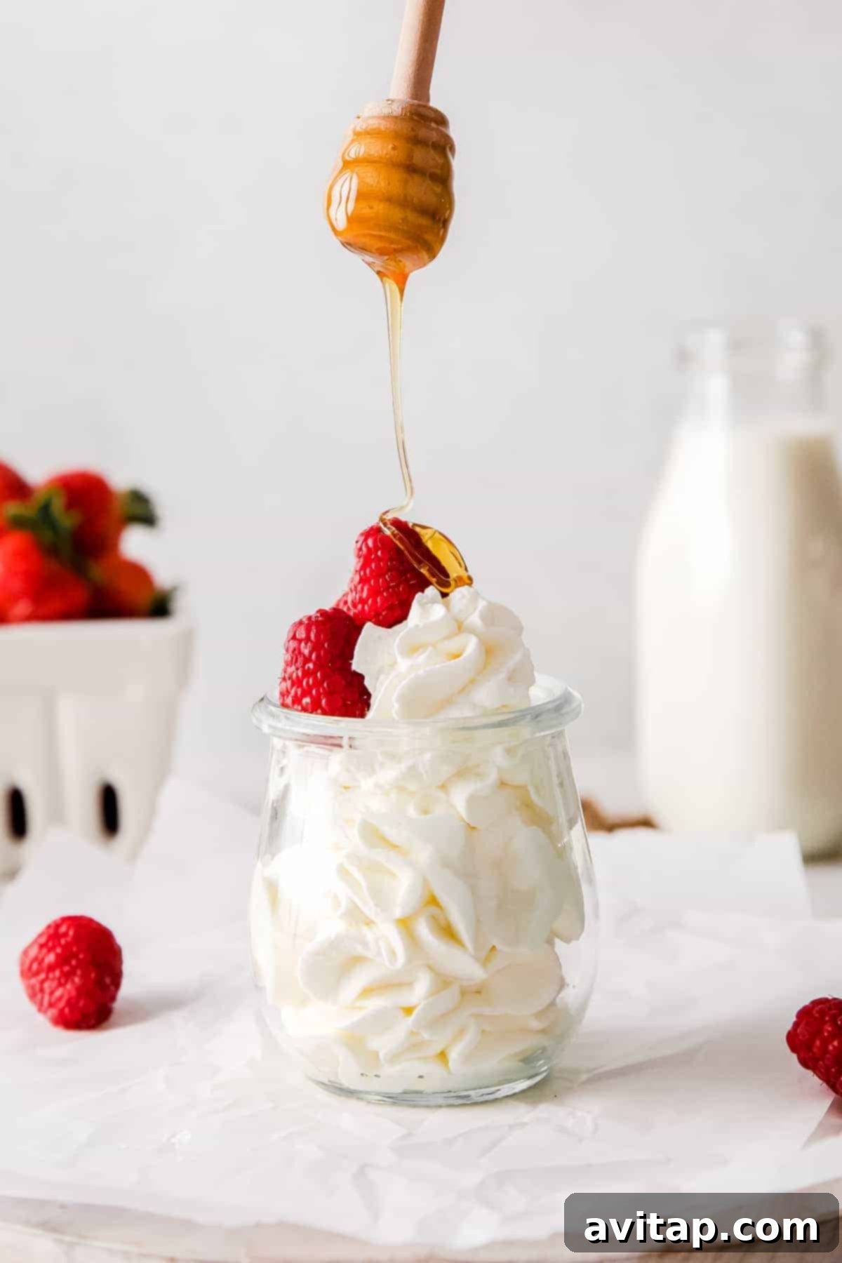 Perfect Homemade Whipped Cream 2 Drizzling honey over a freshly made bowl of homemade whipped cream, ready to serve.