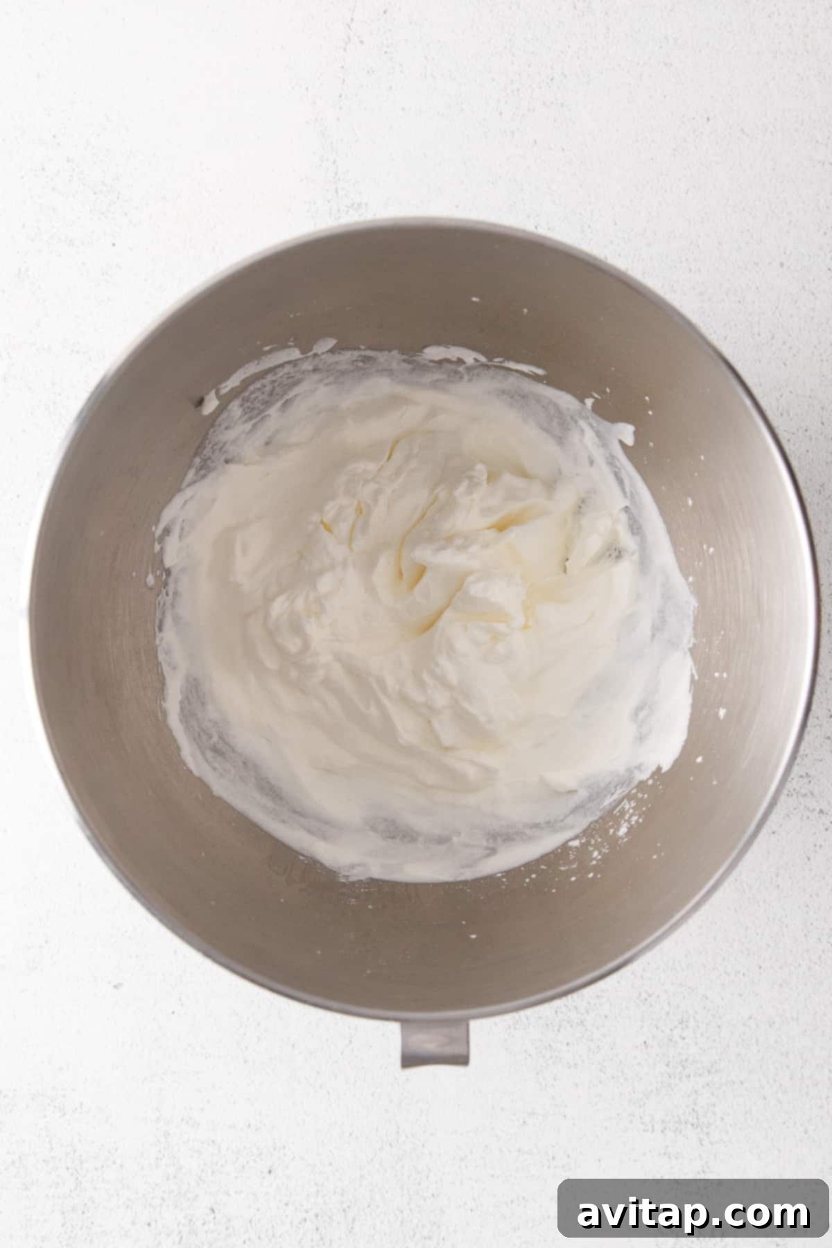 Perfect Homemade Whipped Cream 4 A beautifully whipped bowl of cream, perfectly light and fluffy, nestled in a ceramic bowl.