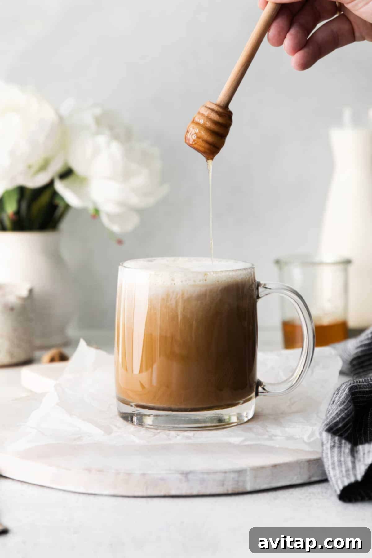 A finished miel latte in a clear glass mug, with a beautiful drizzle of honey on top, emphasizing its sweetness and inviting appeal.