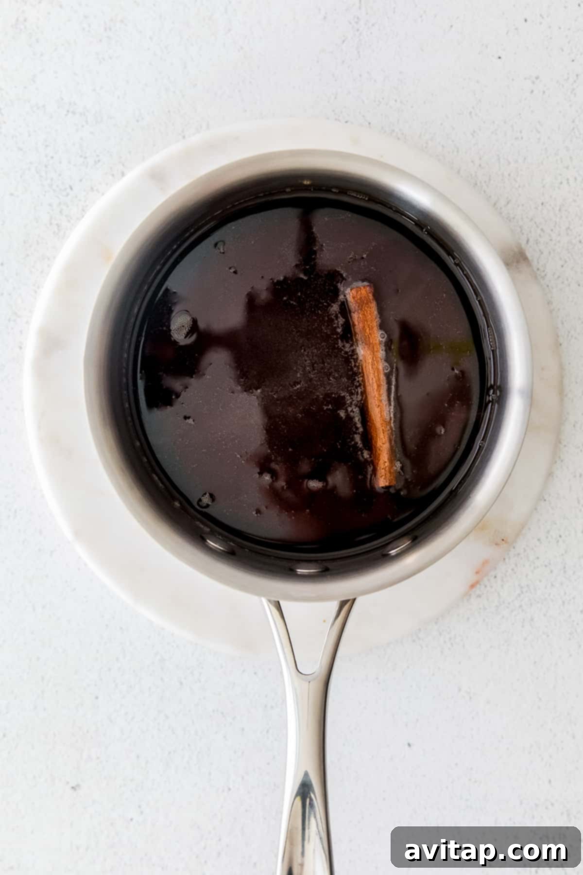 Making Brown Sugar Simple Syrup Brown sugar simple syrup simmering in a pot, infusing with cinnamon.