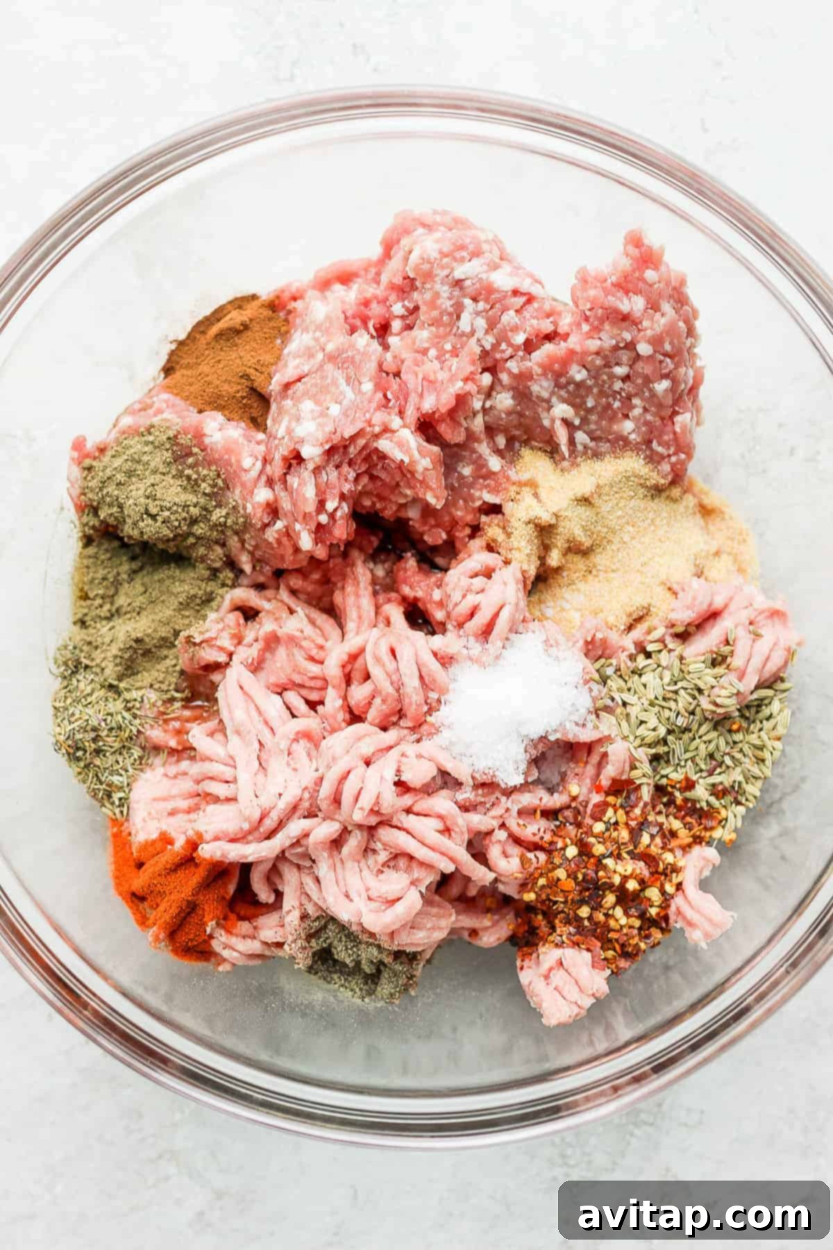 A bowl filled with the ground pork and turkey mixture, seasoned with spices, ready for shaping into breakfast sausage patties.