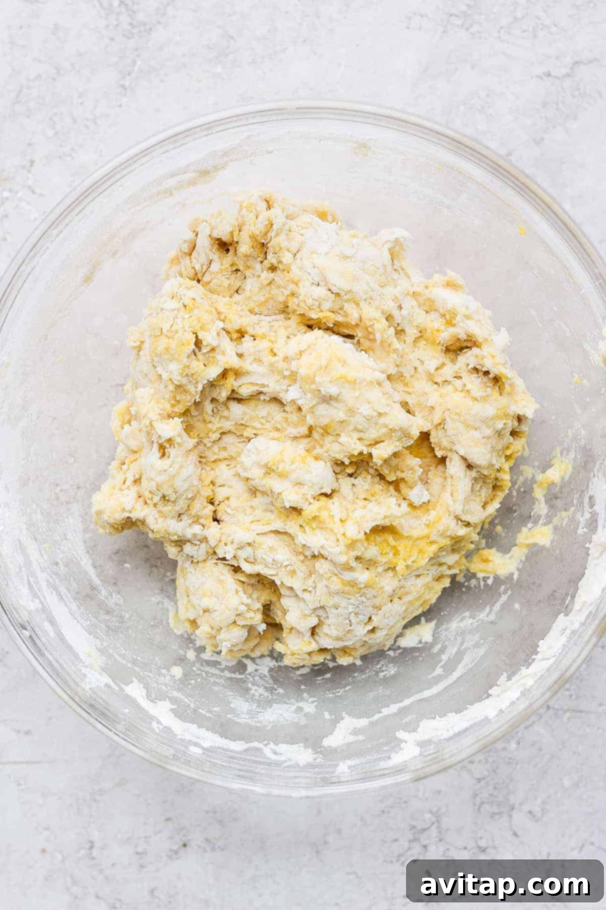 Close-up of sticky homemade dumpling dough in a mixing bowl, ready to be added to the slow cooker.