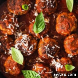 Golden brown turkey meatballs in a skillet, garnished with fresh basil leaves, ready to be served