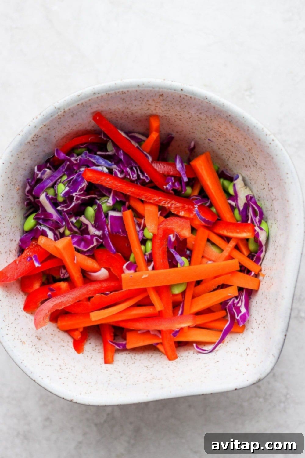 Close-up of the vibrant Thai slaw with purple cabbage, edamame, carrots, and red pepper.