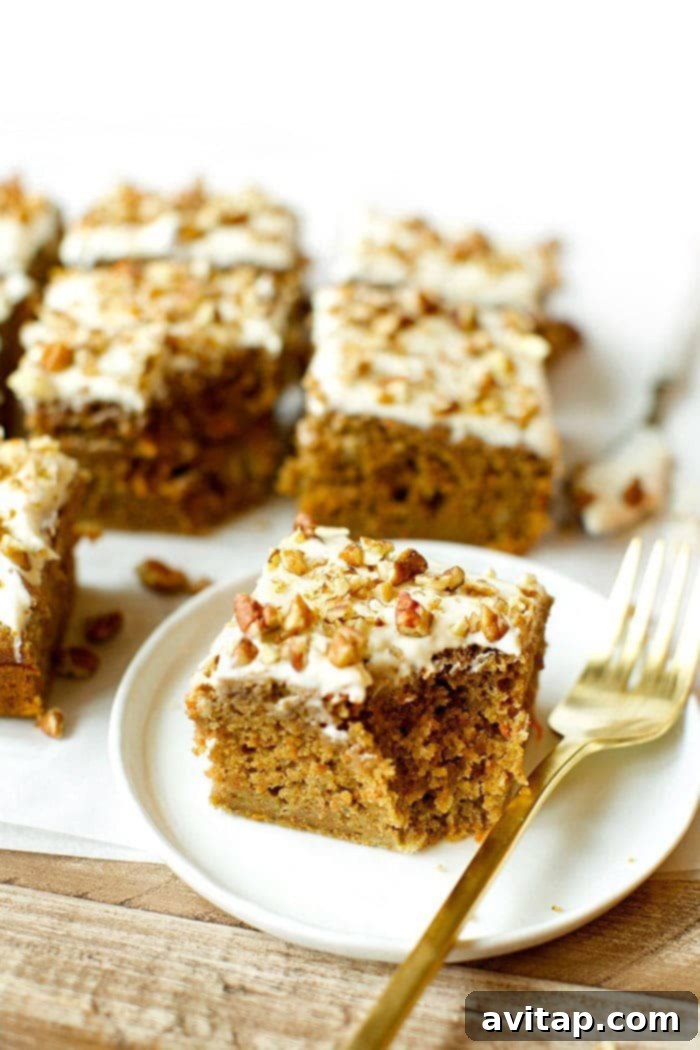 A gorgeous slice of healthy carrot cake on a plate, ready to be enjoyed.