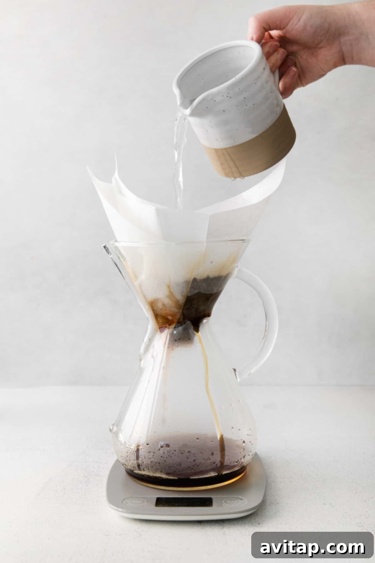 Hot water being poured in a spiral motion over coffee grounds in a Chemex.
