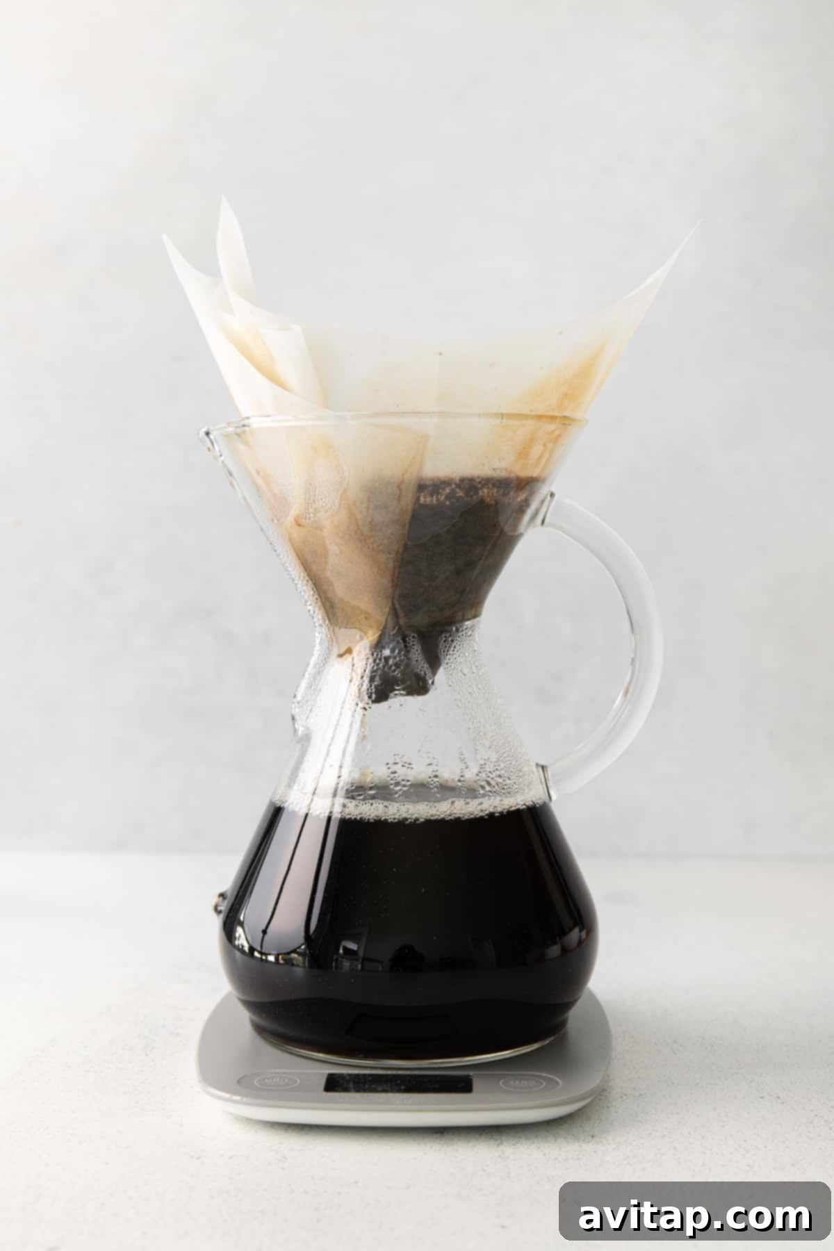 A Chemex filled with freshly brewed pour-over coffee, ready to serve.