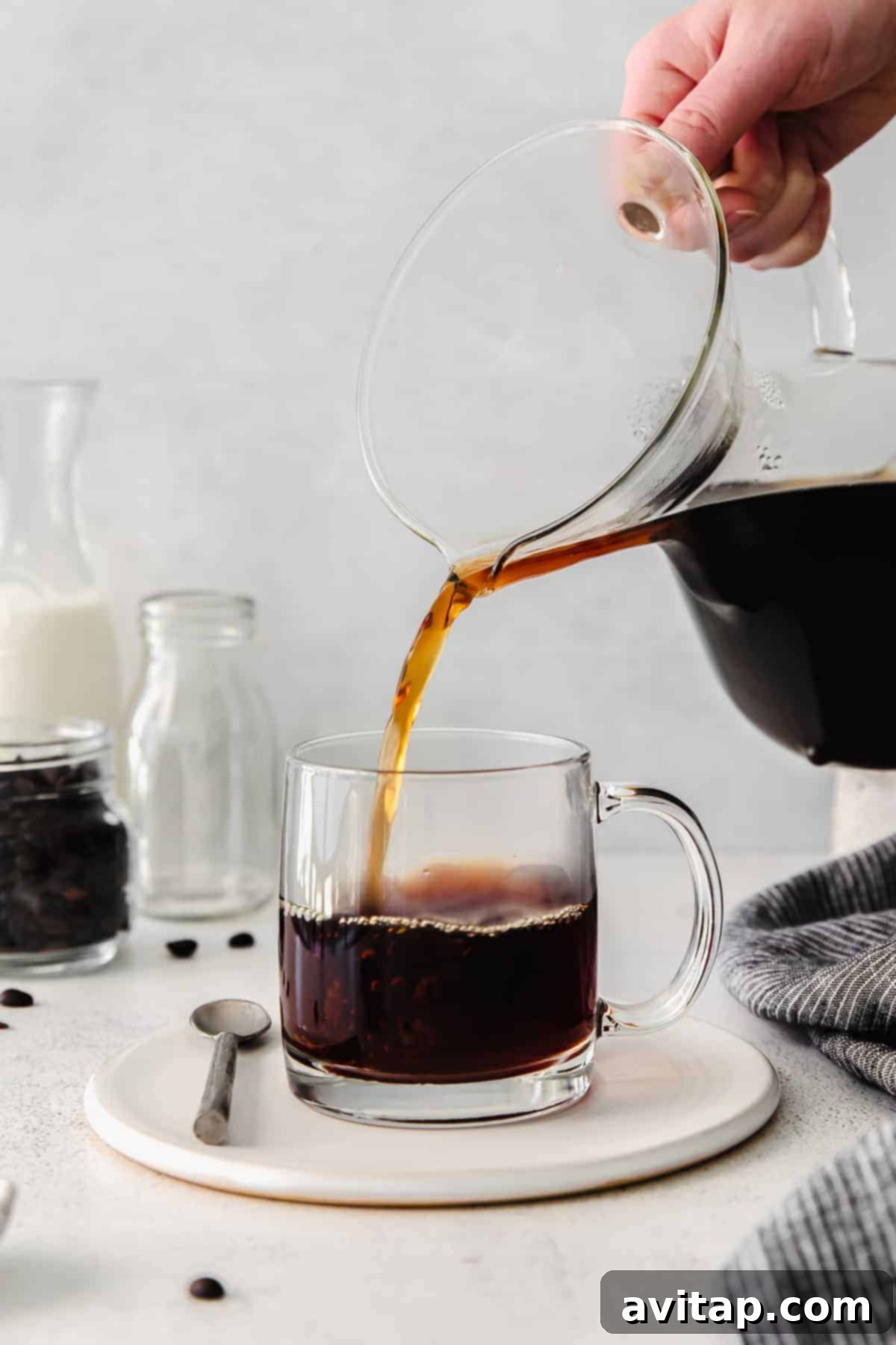 Freshly brewed pour-over coffee being poured into a clean mug.