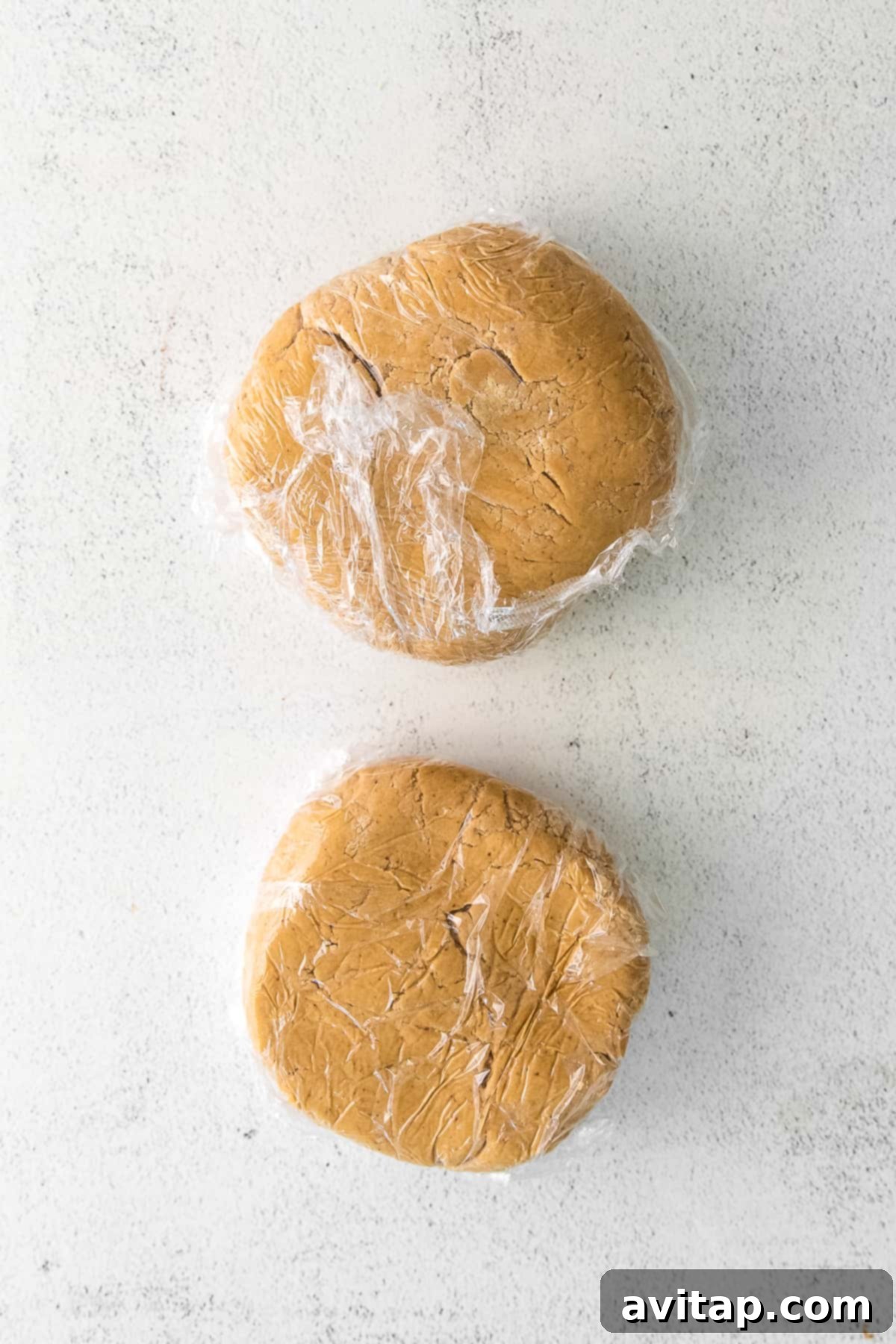 two discs of maple sugar cookie dough, tightly wrapped in plastic wrap and ready for chilling