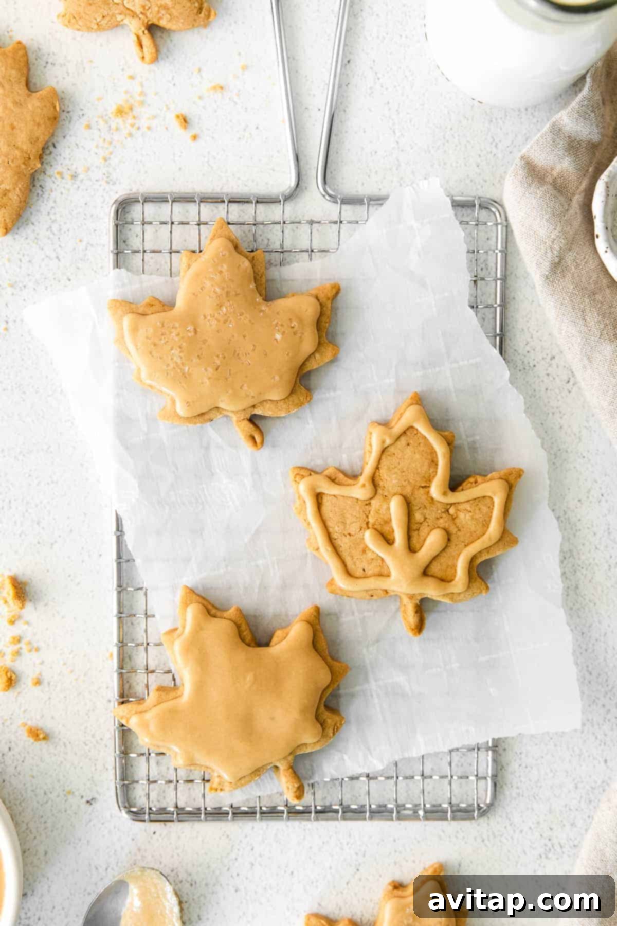 beautifully frosted maple sugar cookies with maple-leaf decorations, arranged on a wire rack