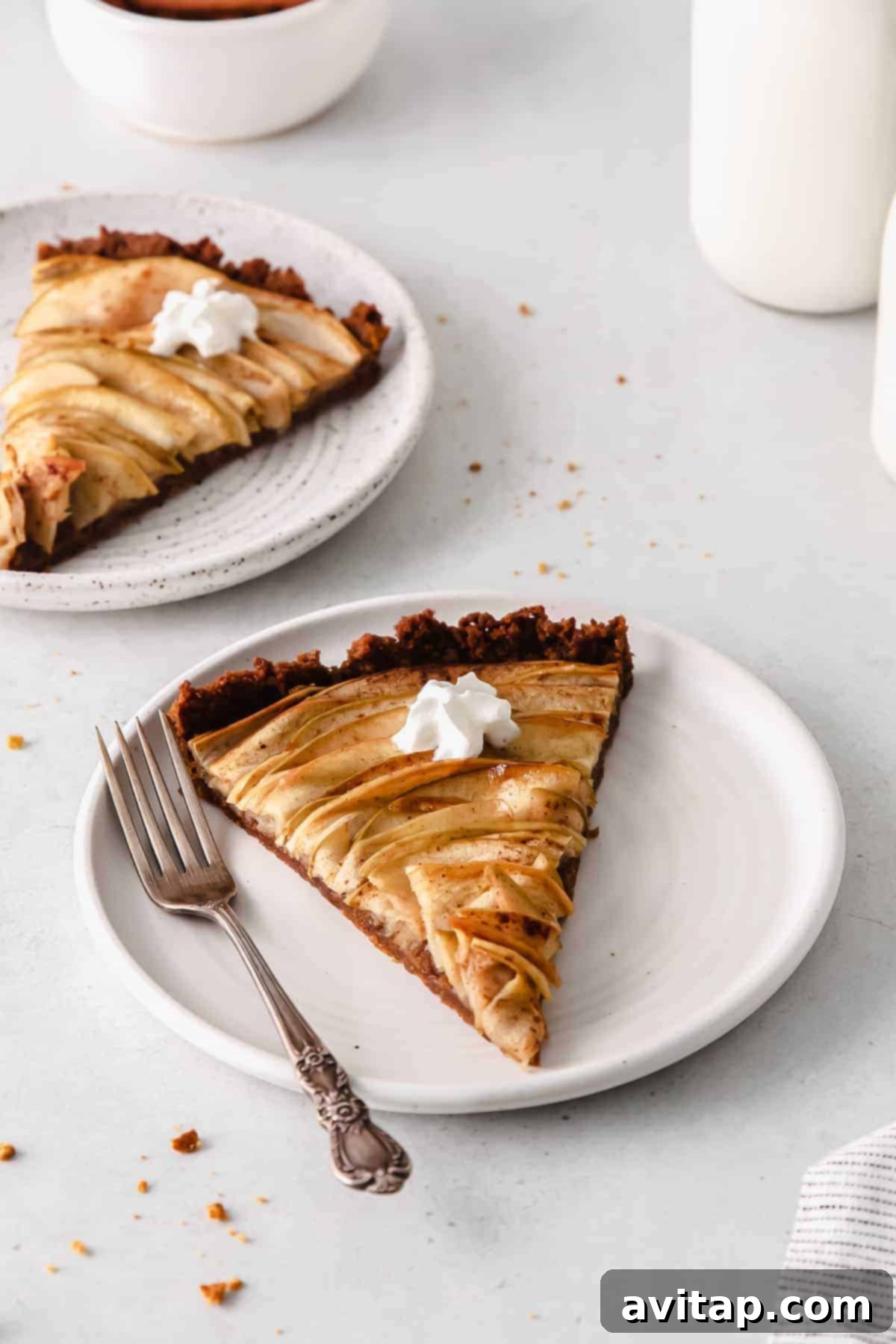 Golden Apple Tart 9 A slice of elegant apple tart on a plate, showcasing the apple rose and golden crust, ready to be enjoyed.