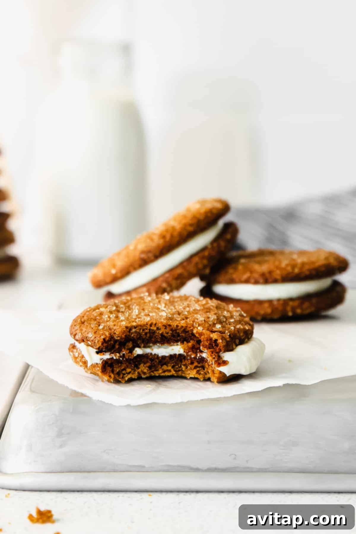 A ginger whoopie pie with a bite taken out, revealing its soft cookie and creamy filling.
