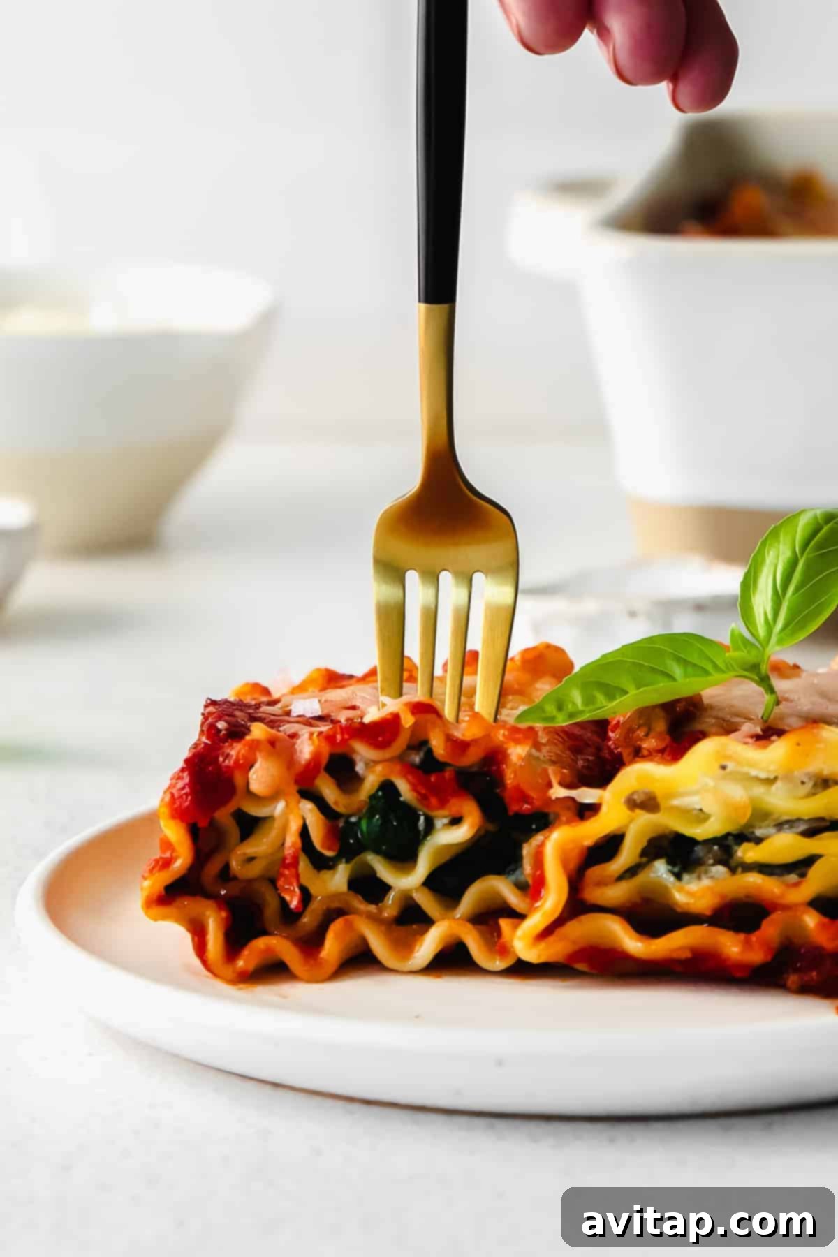 A single, perfectly rolled lasagna roll up, artfully placed on a pristine white plate and elegantly garnished with fresh parsley, presented as a delicious, individual serving, ready to be enjoyed immediately.