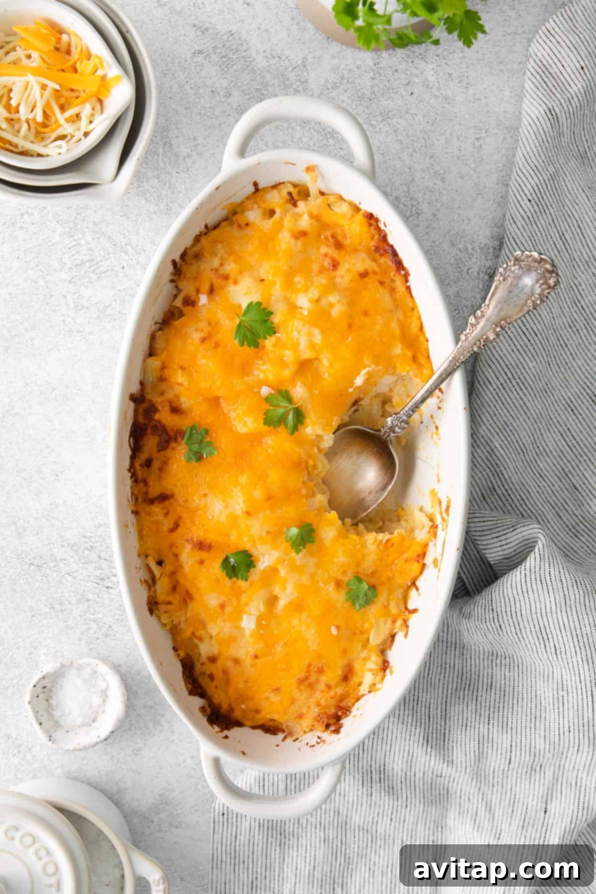 Golden brown cheesy potato casserole in a large baking dish, ready to be served, highlighting its rich, bubbly texture.