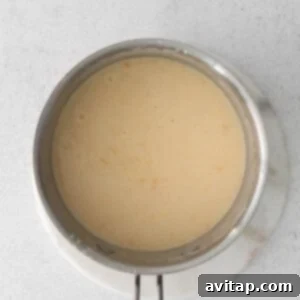 A pan with a creamy sauce in it, highlighting the finished homemade cheese sauce.