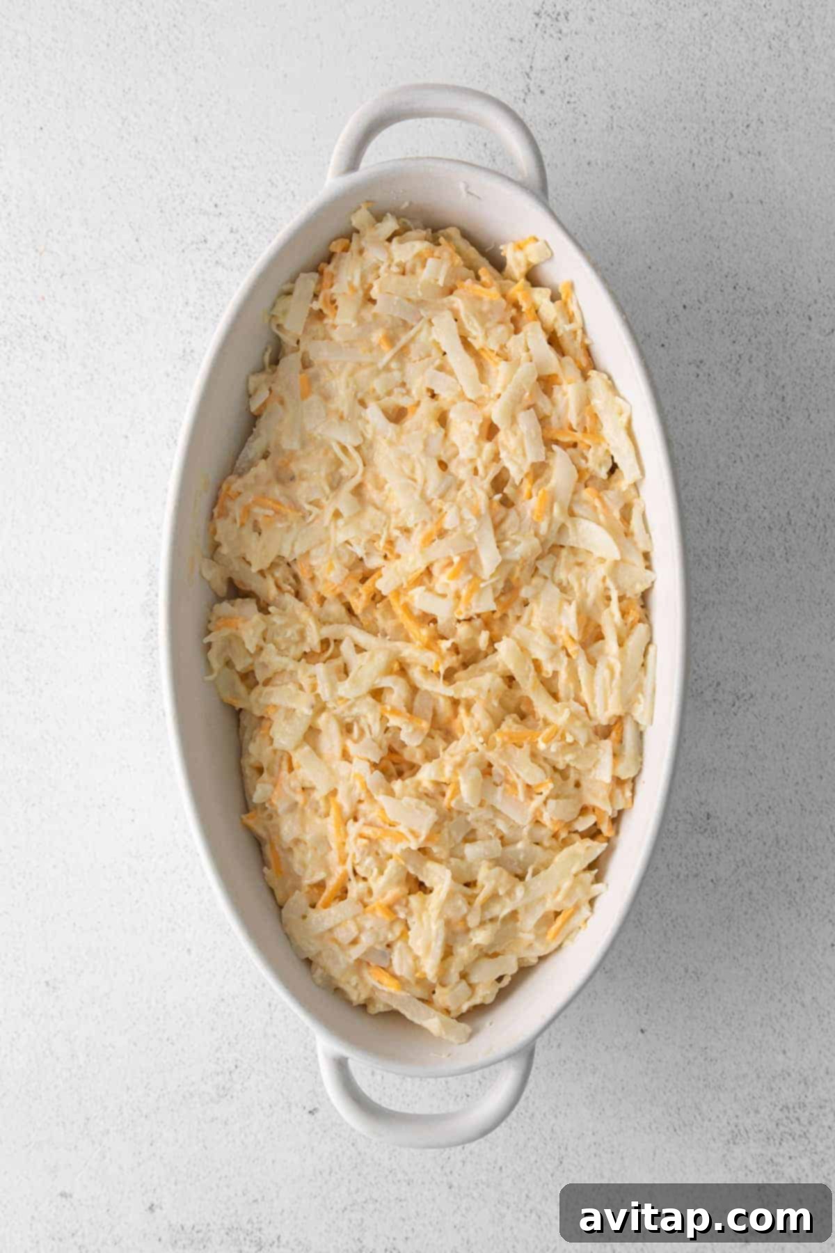 A freshly baked cheesy potato casserole, golden and bubbly, straight out of the oven in a glass baking dish, ready to be enjoyed.