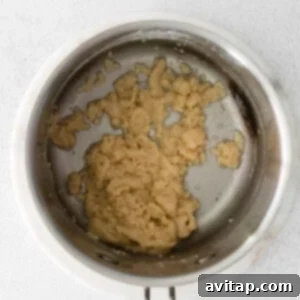 A frying pan with a spoon in it, showing the butter and flour mixture (roux) being prepared.